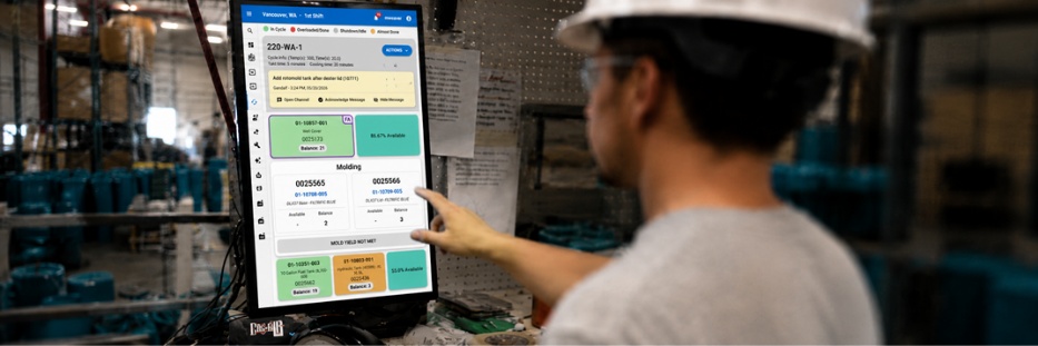 AI Is Moving Manufacturing from Reporting to Action 5 Factory worker using a touchscreen production dashboard on the manufacturing floor.
